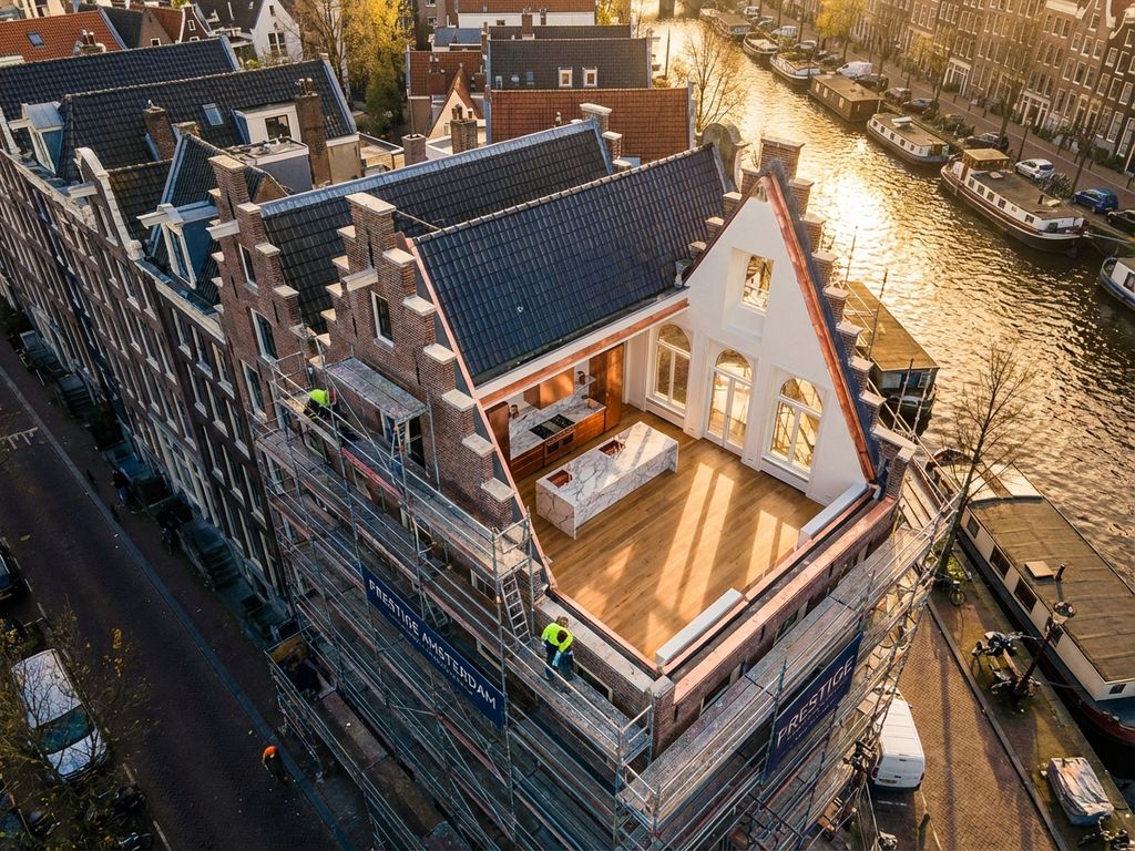 Luchtfoto van Amsterdams grachtenpand tijdens luxe renovatie met moderne keuken en hardhouten vloeren bij gouden uur
